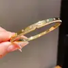 Pulseira fecho banhada a ouro 18K com zircônias cúbicas e padrão torcido, uma pulseira luxuosa e de alta qualidade, um acessório de moda transfronteiriço europeu e americano para mulheres
