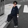 Conjunto de Moletom com Capuz Falso de Duas Peças para Meninos 2026 Novo Primavera/Outono Estilo Coreano Calça Esportiva Xadrez Média a Grande Conjunto de Duas Peças