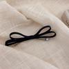 Horquilla minimalista sencilla de temperamento francés para niña, con lazo negro y pinza de resorte en la parte posterior, horquilla rota con clip superior.