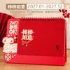 Calendário de mesa vermelho criativo com tema do Ano do Carneiro, apresentando um design vazado, um calendário mensal e um planejador diário, perfeito como um ornamento de mesa para o escritório ou empresa, e disponível para pedidos personalizados.