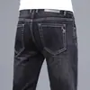 Jeans de alta gama para hombre para primavera y verano, corte recto, ajuste slim, elásticos, pantalones largos de moda de Guangzhou Xintang, estilo versátil de verano