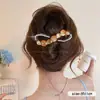 Um grampo de cabelo estiloso e versátil para mulheres, apresentando um design de bico de pato que não pressiona a parte de trás da cabeça, perfeito para criar penteados elegantes no outono e inverno.