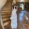 Conjunto de top regata floral estilo francês para férias na praia em Dali Lijiang, Yunnan, com saia de renda em múltiplas camadas