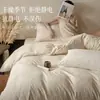 Juego de ropa de cama de cuatro piezas de terciopelo de leche engrosado y bordado para otoño e invierno, que incluye sábanas cálidas, funda de edredón y sábana bajera, diseñado para el dormitorio principal con una estética simple pero elegante.