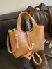 Bolsa transversal de ombro único estilo minimalista de alta qualidade para mulheres, bolsa tipo balde com textura de couro macio, nova bolsa de mão versátil e elegante 2026
