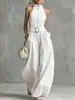 Elegante mono blanco estilo francés con cuello halter, cuello alto, cremallera, cinturón ancho en la cintura y un estilo fluido europeo y americano