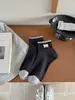 Nuevos calcetines para mujer Primavera/Verano 2026 con etiqueta de tela, diseño de cachorro, borde de encaje, borde acanalado de bloques de color, estilo coreano sin costuras, calcetines de media caña estilo universitario