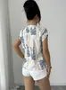 Nuevo top de estampado de tinta transfronterizo europeo y americano con cuello en V, hombros con dobladillo, corte holgado, adecuado para ir al trabajo y para vacaciones, versátil de manga corta