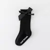 Nuevos calcetines largos de rayas de color sólido para niños y niñas, algodón-poliéster antideslizantes con parte superior de burbuja, calcetines de media pantorrilla con lazo para bebé al por mayor