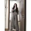 Ahora, una sudadera con capucha gris, elegante y cómoda, combinada con pantalones casuales holgados, crea un conjunto chic de tres piezas al estilo coreano.
