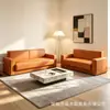 Sofá minimalista de cuero negro de tres plazas, adecuado tanto para uso en la sala de estar como para la relajación, con reposabrazos anchos y cómodos y acolchado de alta resistencia.