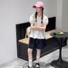 Conjunto de Verão para Meninas 2026 Novo Estilo Camisa de Boneca de Verão Infantil Top de Manga Curta para Meninas Mais Velhas Shorts Jeans Estilosos