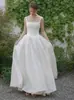 Vestido de noiva leve estilo francês com alças de tafetá, decote quadrado simples e elegante, adequado para fotografia de viagem ao ar livre, com saia volumosa, perfeito para o passeio da noiva