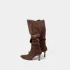 Sin embargo, estas son botas vaqueras de tacón alto de gamuza estilo retro para mujer, que llegan hasta la rodilla, con punta fina, tacón delgado y detalle de hebilla metálica.