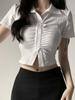 Camisa blanca estilo Spice Girl, corta, ajustada, con hombros descubiertos y cintura plisada, diseño de manga corta.