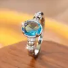 Anillo de estilo europeo con piedra principal ovalada de aguamarina, aro de luz, sensación de lujo de alta gama, diseño denso de pavé con pequeños diamantes en ambos lados