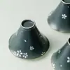 Taza de té pintada a mano con patrón floral blanco y diseño de sombrero de bambú, con un estilo delicado y refinado, perfecta para disfrutar del té en casa en un ambiente inspirado en el Zen.