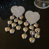 Brincos Europeus e Americanos de Agulha de Prata com Coração Cravejado de Diamantes e Borla 2026 Novo Estilo Estética Fria Personalidade Tarraxas de Orelha Nicho Toque de Luxo Ornamentos de Orelha