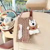 A caixa de lenços de carro Blue Rain, com um fofo padrão xadrez, é um acessório criativo para carro projetado para ser pendurado no encosto do banco.