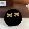 2025 Novos Brincos de Ouro Acessíveis de Luxo de Alta Gama Cor Dourada Brincos Antigos em Forma de Laço Nicho Simples Versáteis Brincos Brincos
