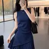 Un impresionante conjunto de dos piezas de verano para bellezas petite: una camisola azul marino asimétrica y una minifalda plisada