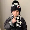 Novo estilo conjunto de chapéu e cachecol de malha xadrez com rosto sorridente em jacquard para crianças, chapéu de malha espesso de inverno quente com pompom