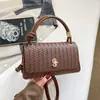 Bolso de mano con textura tejida para mujer 2026 nuevo de alta gama versátil de un solo hombro cruzado diseño con sentido bolso baguette para ir al trabajo