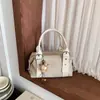 Bolsa de mão feminina estilo coreano com design de rebites de nicho, versátil e elegante para o outono, com estética de alta qualidade e alça de ombro, semelhante a uma bolsa almofada
