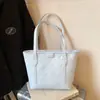 Bolso tote moderno y práctico de gran capacidad con un diseño de dibujos animados en relieve, un nuevo y elegante bolso de hombro y un bolso tipo cubo adecuado para estudiantes universitarios.