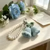 Chaveiro de flor de lírio-do-vale de crochê feito à mão transfronteiriço Pingente de bolsa de flor de fio Pequenos acessórios de presente para meninas