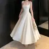 Falda larga estilo francés de 2026 que ciñe la cintura con un bajo amplio, vestido de compromiso para registro, elegante vestido blanco de tirantes para mujer