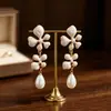 Pendientes colgantes retro de estilo francés de doble capa con flores, que presentan delicados pétalos blanco lechoso, perlas en forma de lágrima y un toque de lujosa elegancia cortesana