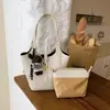 Bolso tipo cubo de gama alta para mujer, nuevo estilo 2026, con dijes decorativos, un bolso de hombro ligero y lujoso, versátil para ir al trabajo y se puede llevar debajo del brazo