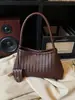 Bolso de mano tejido de nicho coreano para mujer, moda retro casual de moda nuevo otoño 2026, bolso de hombro bajo el brazo