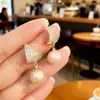 Brincos de Pérola Totalmente Cravejados de Diamante Brilhante Super Leve de Luxo Banhados a Ouro Real Novo Design Tendência de Nicho Brincos de Tarraxa com Coração Microincrustado Venda por Atacado