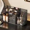 Tocador de estilo abierto con estantes escalonados para organizar cosméticos, productos para el cuidado de la piel, labiales, mascarillas faciales y lápices de cejas.