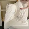 Uma colcha floral bordada delicada e elegante, adequada para todas as estações, feita de algodão macio e lavável e preenchida com fibra de soja.