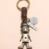 Llavero de cuero de vaca tejido retro personalizado para joyería transfronteriza, llavero de robot de dibujos animados creativo con manos y pies móviles
