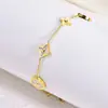 Pulsera de Acero de Titanio Chapado en Oro de 18K Estilo Nuevo Transfronterizo con Trébol de Cuatro Hojas y Concha Blanca para Mujer, Moderna y Versátil, Sensación de Alta Gama, Joyería que no se Desvanece
