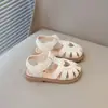 Sapatos de couro respiráveis com design vazado estilo coreano para crianças, novos modelos de sandálias de verão 2026 para meninas, bico fechado, sola macia, sapatos de bebê.