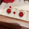2024 nuevo rojo uno dos piezas Perla flor de cuatro hojas estilo chino aretes femeninos temperamento moda todo-partido joyería para orejas