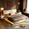 Cama matrimonial de color crema, diseño flotante, sin cabecero, con tira de iluminación LED debajo de la cama, unidad de almacenamiento de gran capacidad en el dormitorio principal y una estructura de cama cubierta de cuero.