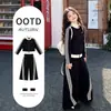 Conjunto de roupa esportiva listrada estilo coreano para meninas para primavera e outono, nova coleção 2026, com jaqueta com zíper e calça de perna larga, um conjunto de duas peças estiloso e moderno