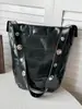 Bolsa de balde casual de grande capacidade para mulheres, novo modelo outono 2026, alto valor estético, cor sólida, design de rebite, bolsa de ombro simples para o dia a dia