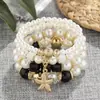 Pulsera Bohemia Europea y Americana de Perlas de Imitación y Estrellas de Mar Blanca de 4 Hilos Estilo Vacaciones en la Costa Pulsera de Moda de Estrellas de Mar