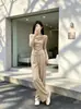Moda de principios de otoño: un conjunto completo de dos piezas puro y seductor para mujer que presenta un top tipo dos piezas falso y pantalones de pierna ancha, creando un look elegante y chic