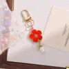 Novo pingente de chaveiro de flor de esmalte colorido estilo INS, um acessório criativo e versátil de liga DIY com face sorridente dupla face