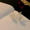 Brincos de diamante doces e requintados Brincos de pérola em forma de cruz coreanos Brincos femininos com design simples e exclusivo Atacado