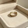 Anillo retro floral en tono café dorado, una pieza lujosa y única con un aire de alta gama, diseñado para apilar, con un borde de encaje, y perfecto para el dedo índice, ofreciendo un estilo moderno e individual
