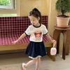 2026 Verano Nuevo Estilo Moda Coreana para Niñas Dibujos Animados Camiseta Delgada Falda Azul Marino para Niños Conjunto de Dos Piezas Moderno